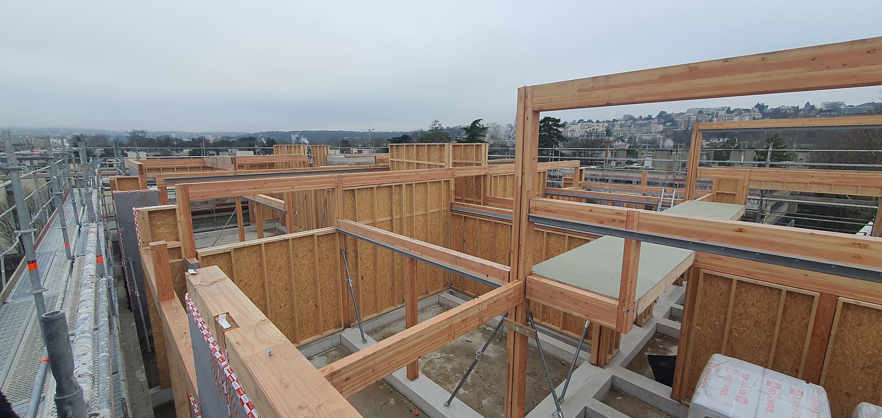 Ossature bois de la surélévation posée sur la toiture d'un immeuble de bureaux, vue depuis l'échafaudage